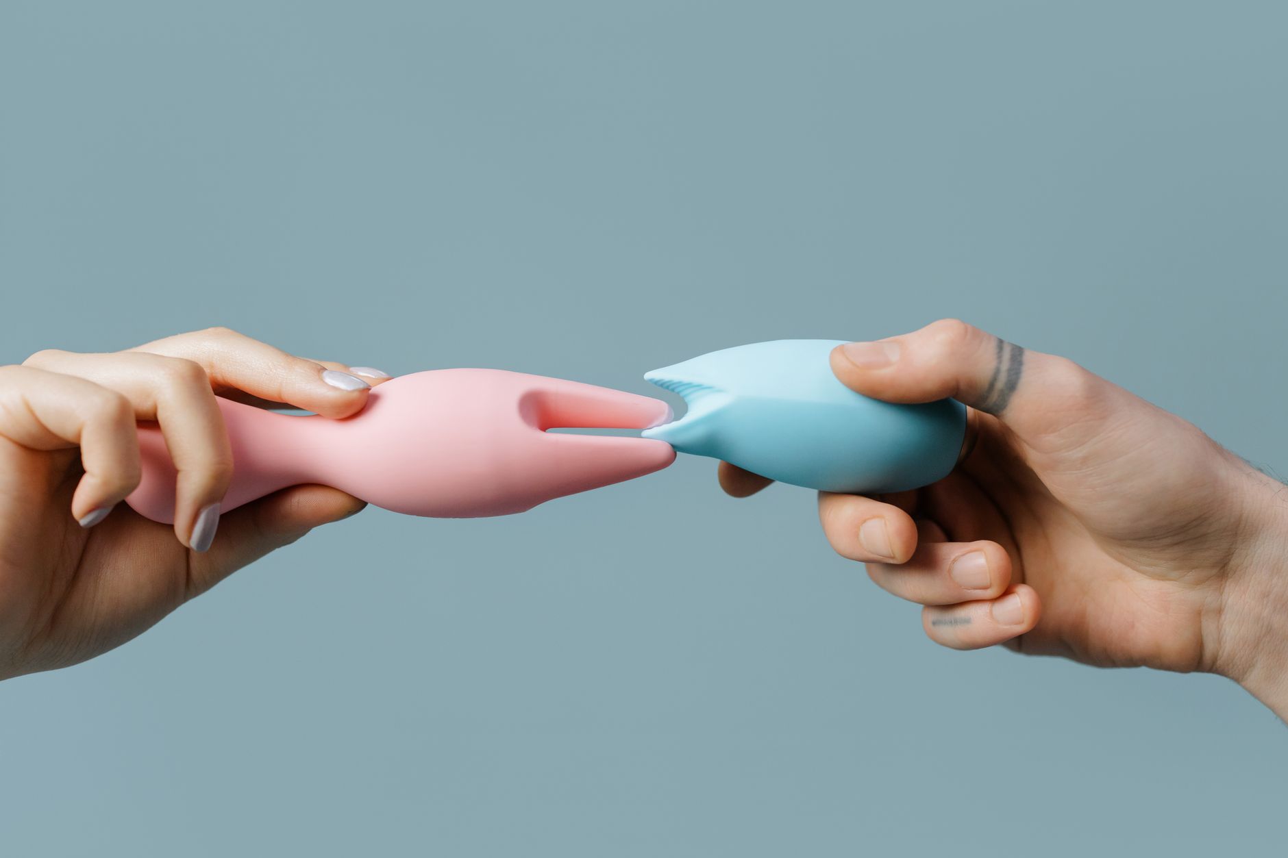 Close-up of hands holding a lemon vibrator, with books in the background